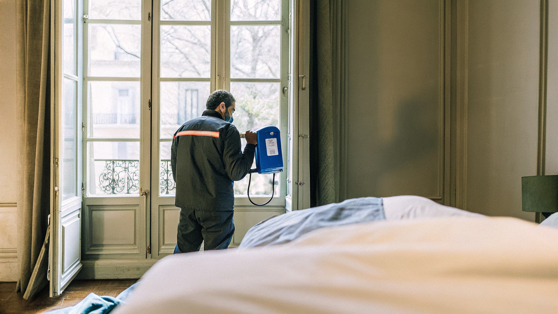 Technicien Sanalia réalisant un traitement thermique contre les punaises de lit dans un appartement parisien